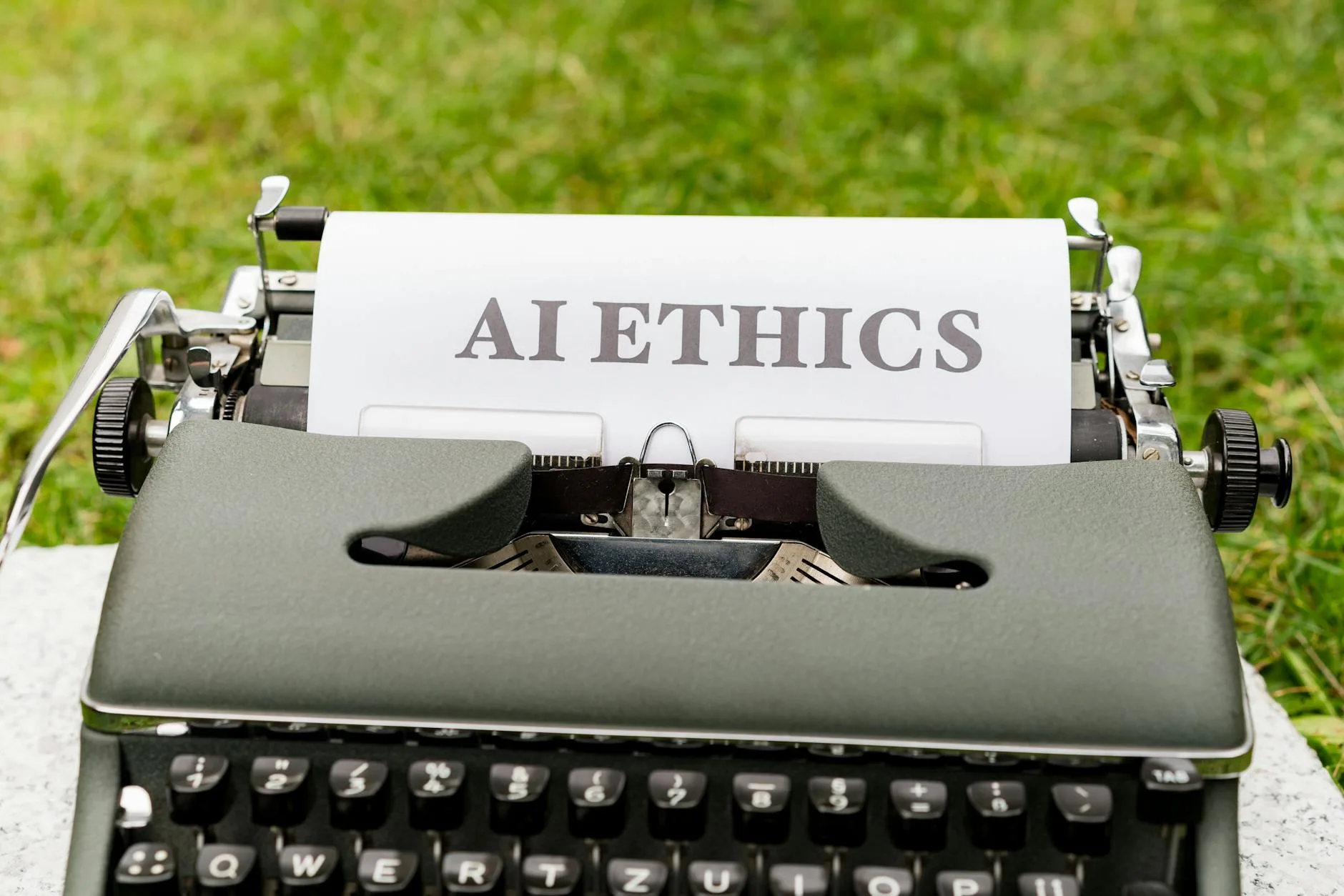 Jak bezpiecznie wdrożyć sztuczną inteligencję w firmie: praktyczny przewodnik dla biznesu Stara maszyna do pisania na dworze z kartką z napisem AI ethics