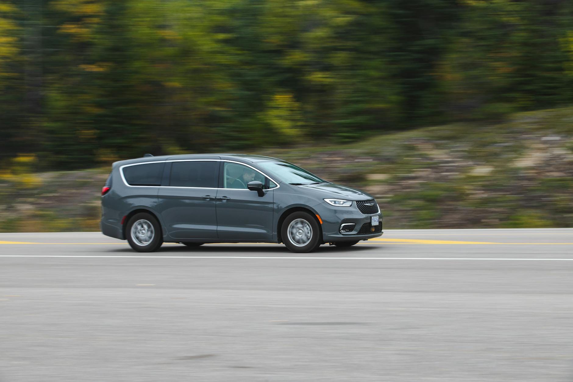 Minivan Changan jedzie autostradą w zielonym, malowniczym otoczeniu Minivan Changan jedzie autostradą w zielonym, malowniczym otoczeniu