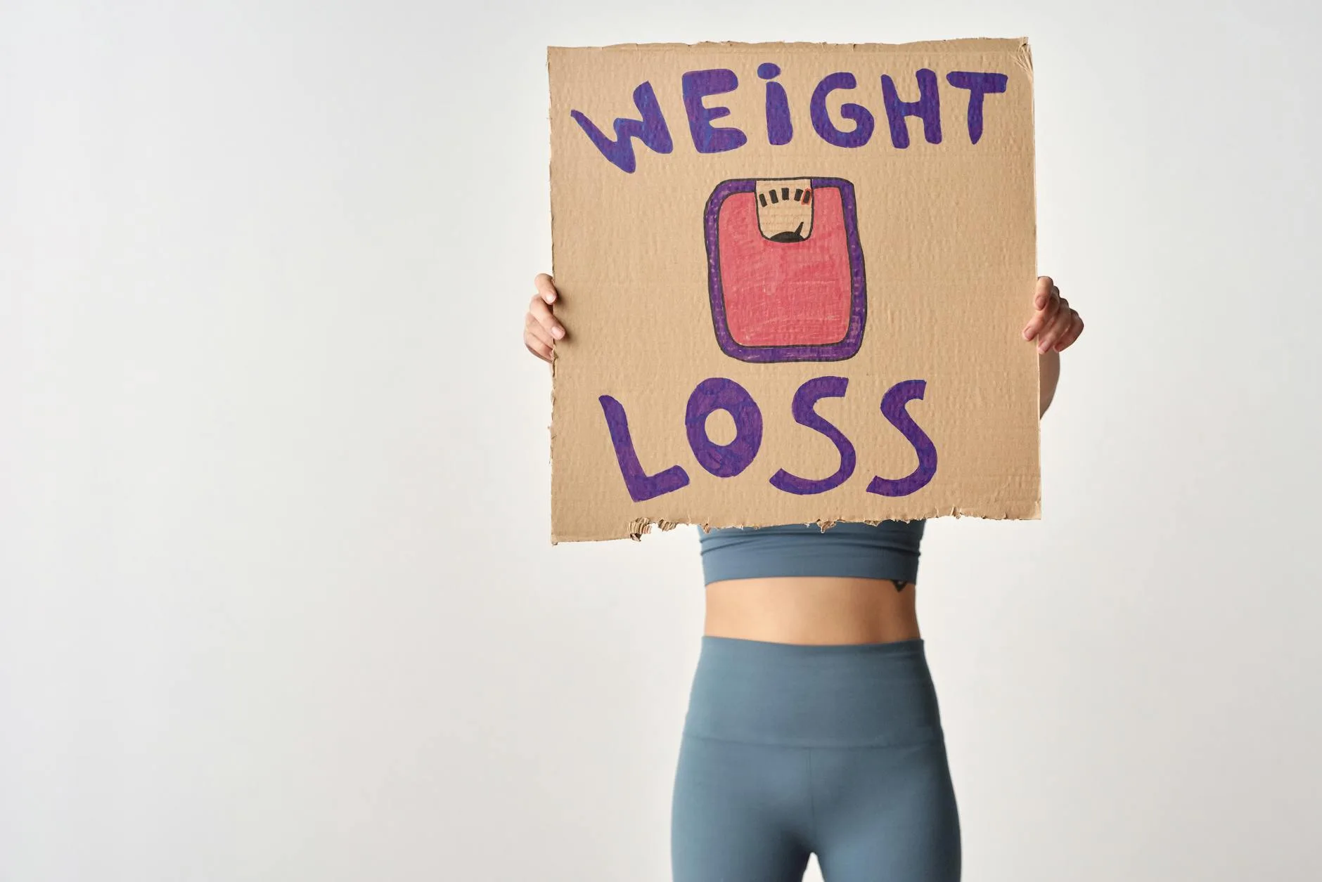 Skuteczne odchudzanie bez głodówek: jak łączyć dietę i trening, żeby trwale schudnąć Osoba trzymająca kartkę z napisem weight loss jako motywacja do odchudzania
