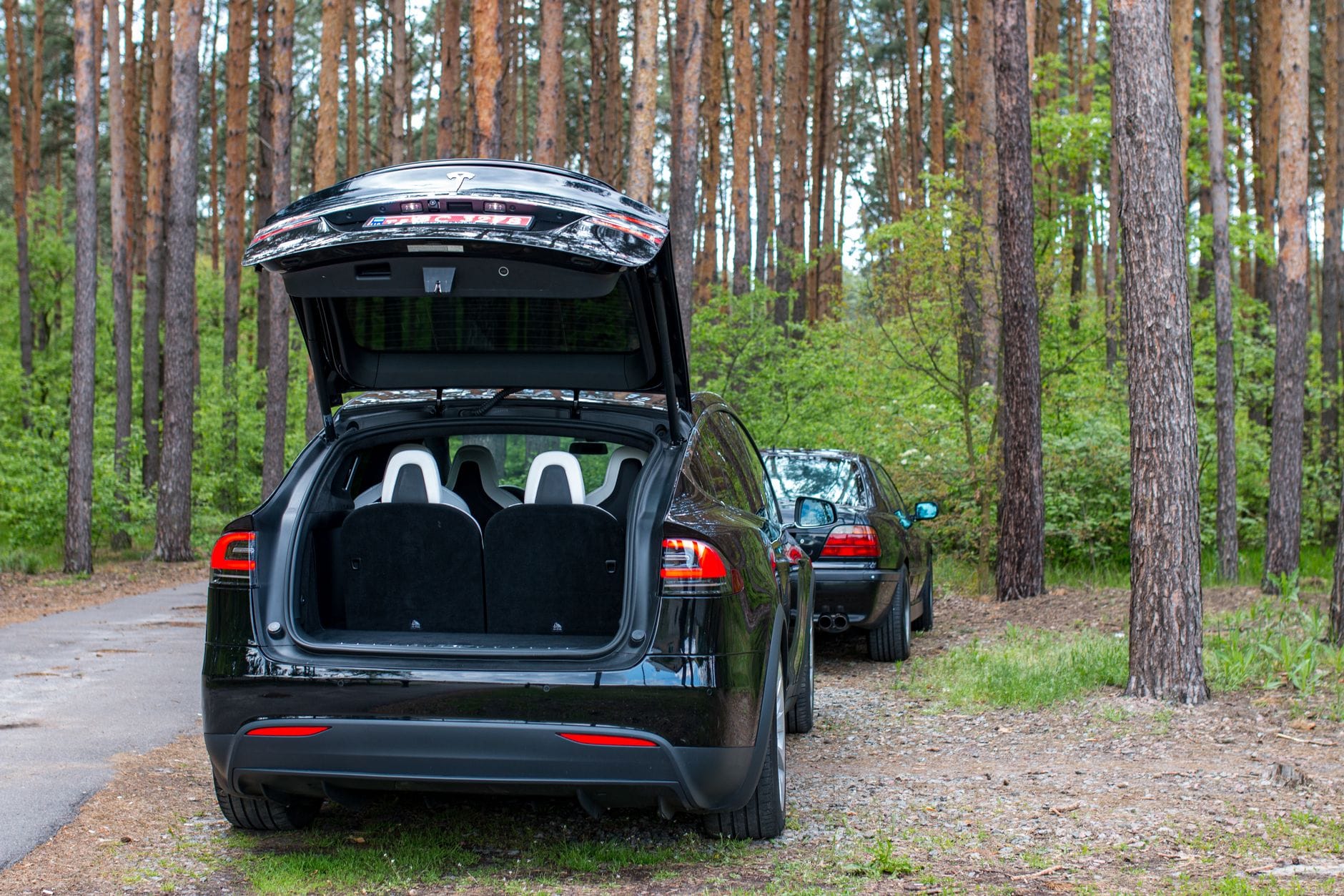 Elektryczny SUV Skoda Enyaq z otwartym bagażnikiem w lesie