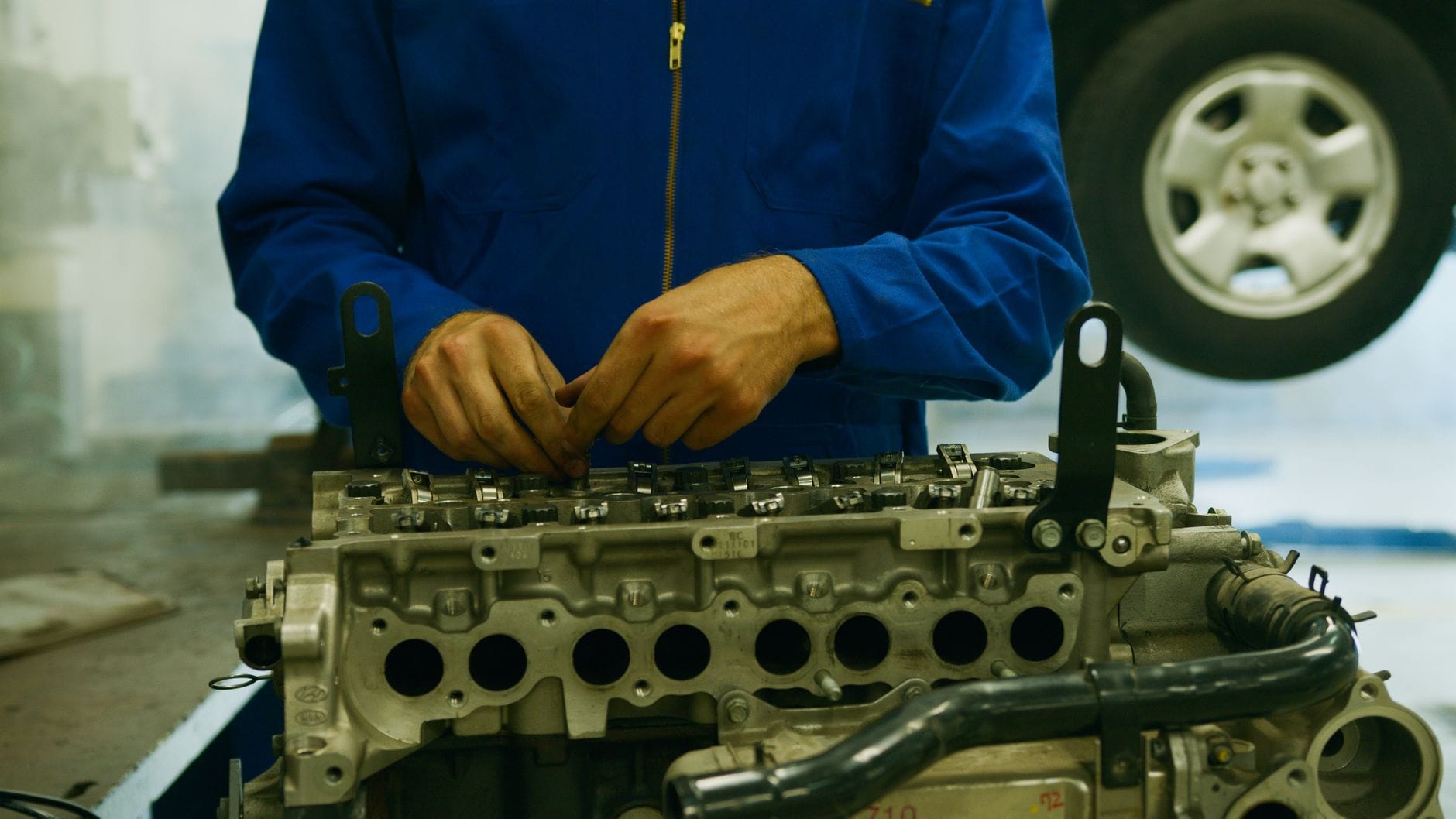 Mechanik naprawiający silnik Peugeota 3008 w warsztacie Mechanik naprawiający silnik Peugeota 3008 w warsztacie