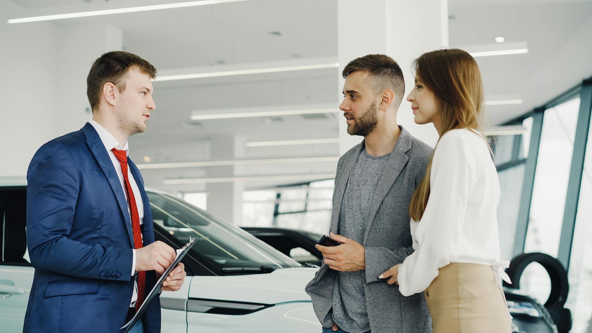 Jak negocjować cenę używanego Ferrari: argumenty kupującego, które rzeczywiście działają w salonach i komisach Sprzedawca pokazuje parze luksusowe czerwone Ferrari w salonie