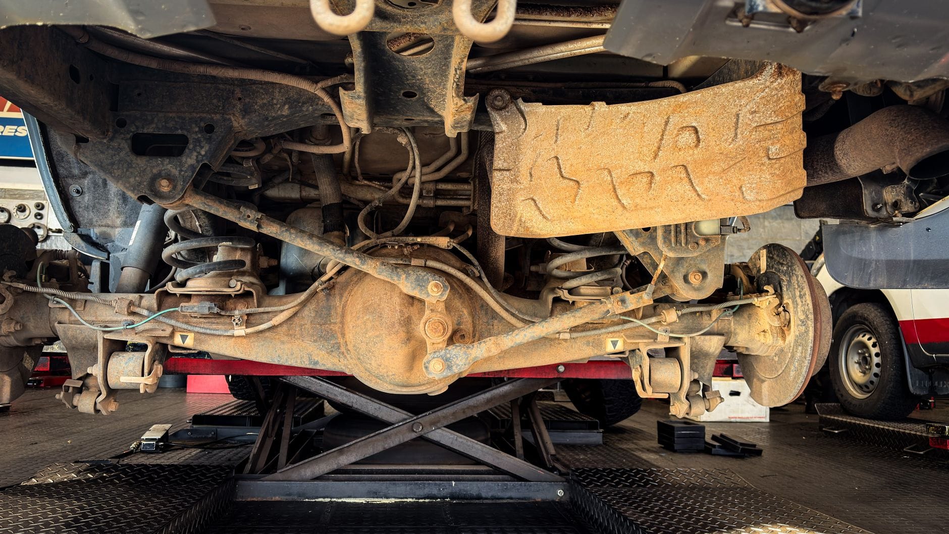 Zardzewiałe elementy zawieszenia Citroëna podczas naprawy w warsztacie