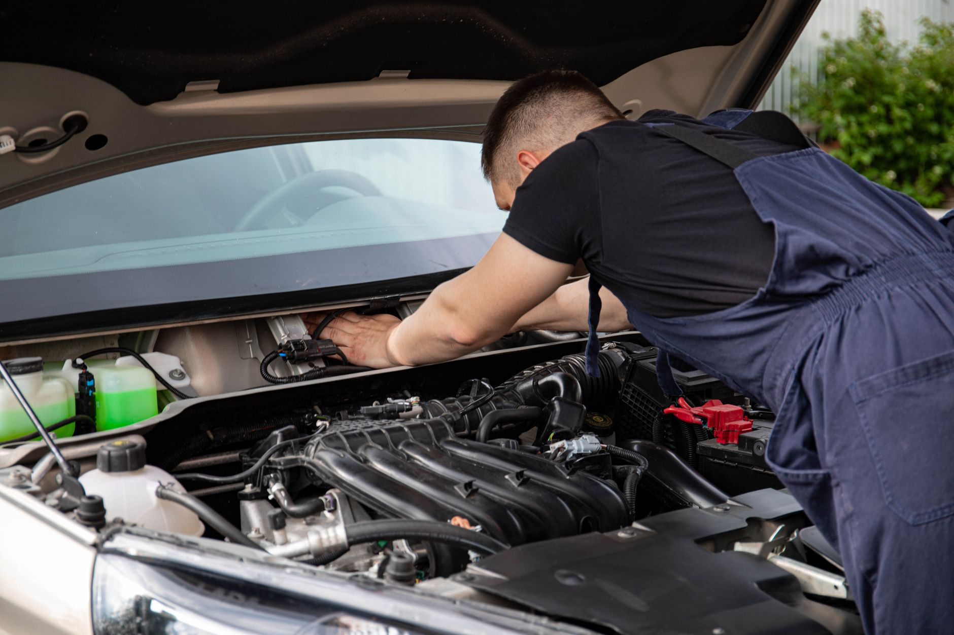 Mechanik serwisuje silnik Suzuki Vitary, zbliżenie na dłonie